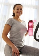 Woman in sports attire riding exercise bike indoors