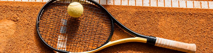 Tennis racket and ball on clay court